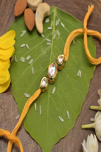 Gold Tone Kundan Rakhi With Yellow Cotton Thread