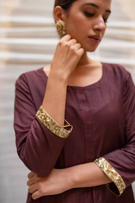 Brown cotton silk straight kurta with hand embroidered sequin zardozi border on sleeves .The kurta is paired with pants. 5