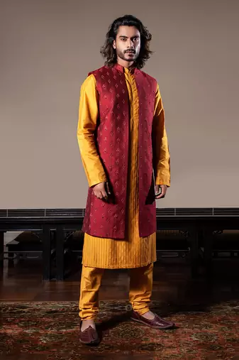 Honey Yellow Thin Pleats Kurta And Churidar With Maroon Embroidered Jacket.