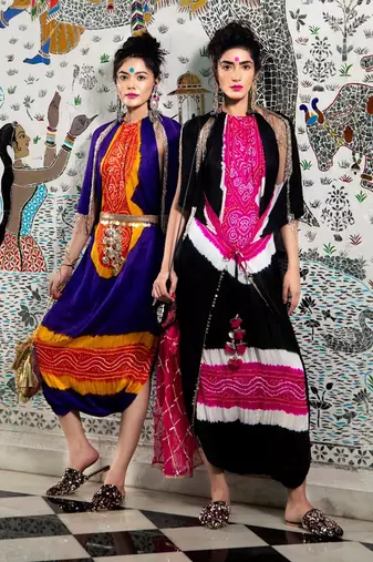 Purple and orange jumpsuit with cape jacket highlighted with gold and gota tassels.