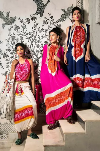 Cream and fuchsia gajji silk dhoti with halter blouse embellished with gota tassels.