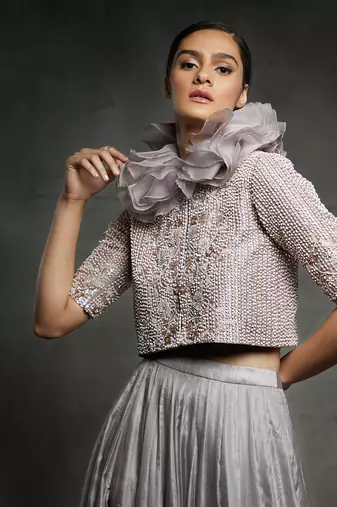 Featuring a dull lilac slit skirt with embroidered  jacket and ruffle neck