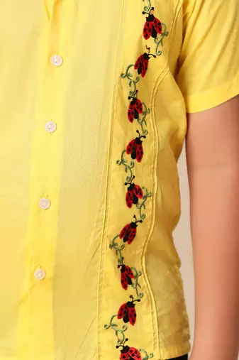 Yellow embroidered shirt with black trousers