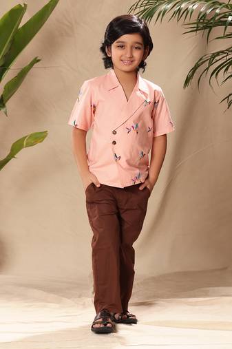 Pink embroidered blazer style shirt with brown trousers