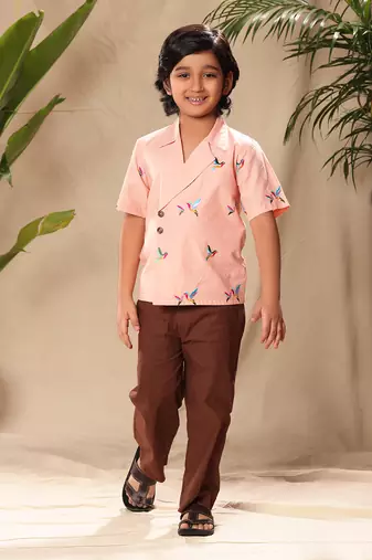Pink embroidered blazer style shirt with brown trousers