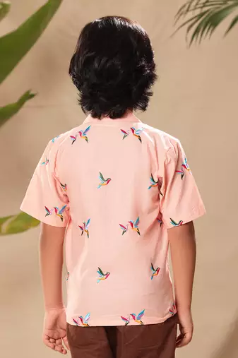 Pink embroidered blazer style shirt with brown trousers