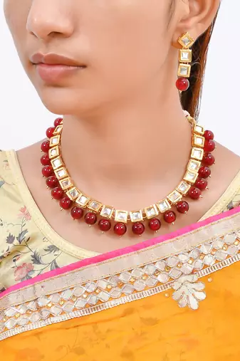 Women gold-plated & red kundan stone-studded jewellery set