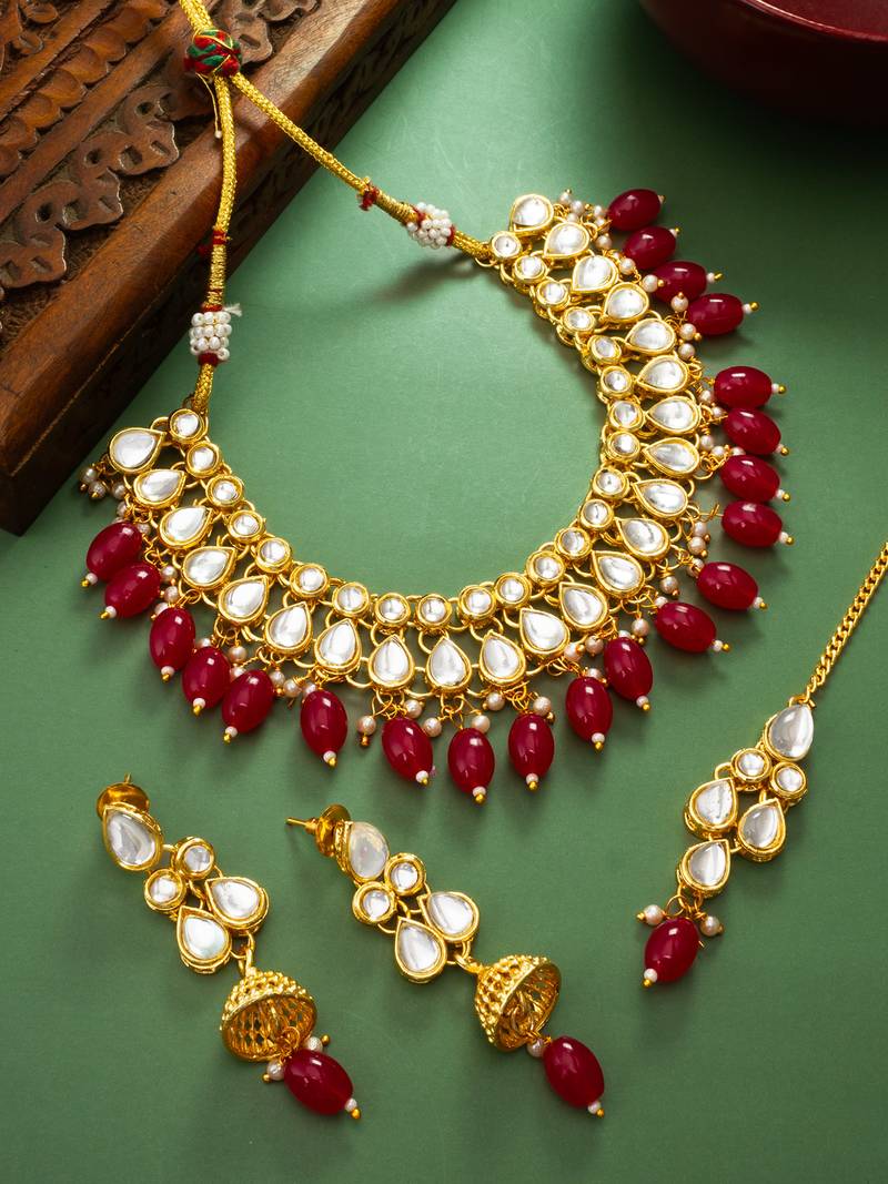 Gold plated kundan stone studded jewellery set with pair of earring and mangtikka