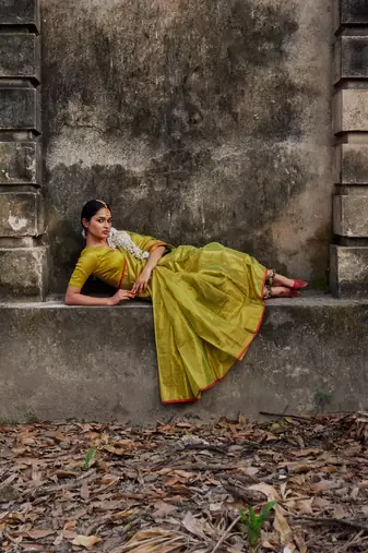 Solid neon green handloom tissue saree with red border
