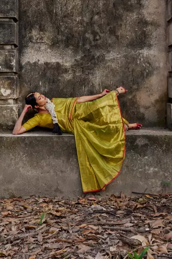 Solid neon green handloom tissue saree with red border