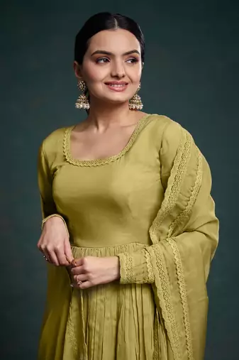 A olive green color anarkali suit with lace detailing ,paired with a lightweight matching dupatta.
