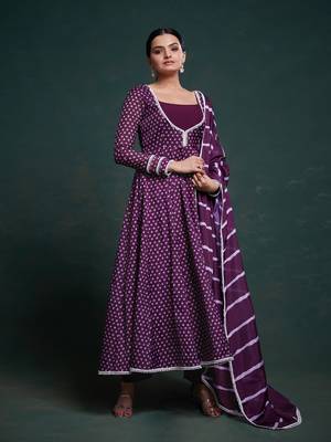 A regal deep purple anarkali dress adorned with a bandhani-inspired pattern and detailed piping along the edges. 1