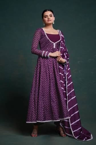 A regal deep purple anarkali dress adorned with a bandhani-inspired pattern and detailed piping along the edges.