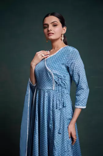 A classic blue polka dot anarkali kurta paired with pants, a flared hemline and detailed lace trim for a timeless look.