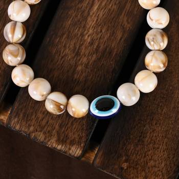 Nvr unisex cream-colored evil eye elasticated rakhi with roli chawal 2