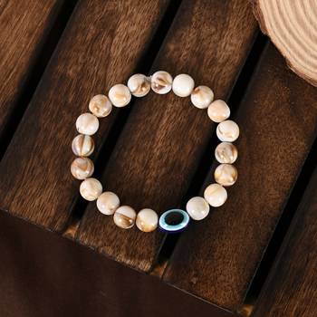 Nvr unisex cream-colored evil eye elasticated rakhi with roli chawal 1