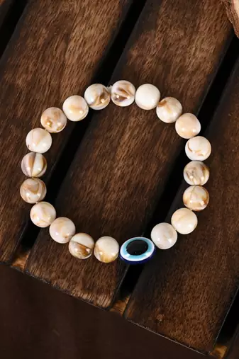 Nvr unisex cream-colored evil eye elasticated rakhi with roli chawal