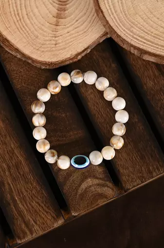 Nvr unisex cream-colored evil eye elasticated rakhi with roli chawal