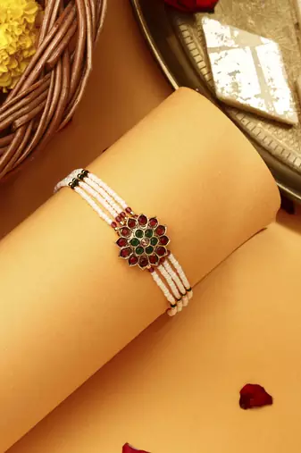 Red & green stone studded flower pearl rakhi bracelet