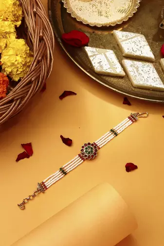 Red & green stone studded flower pearl rakhi bracelet