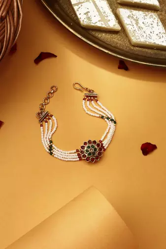 Red & green stone studded flower pearl rakhi bracelet