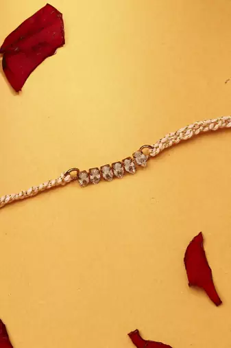 American stone studded rakhi with peach thread