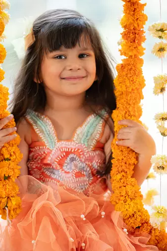 Orange net embroidered sequin frilled lehenga with floral cutwork crop top