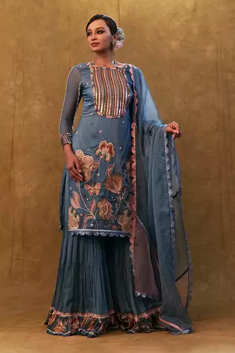 Blue applique work kurta set paired with flared sharara and a dupatta.