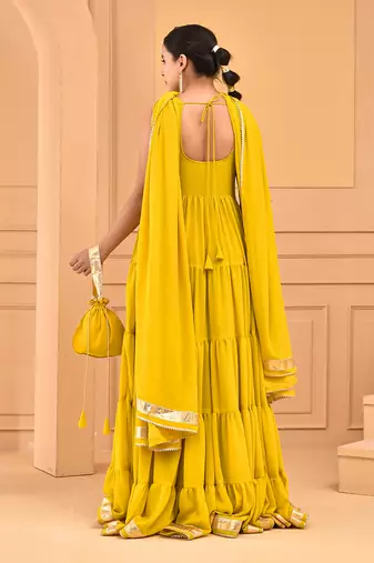 Mustard floor length tiered anarkali  paired with dupatta and potli bag