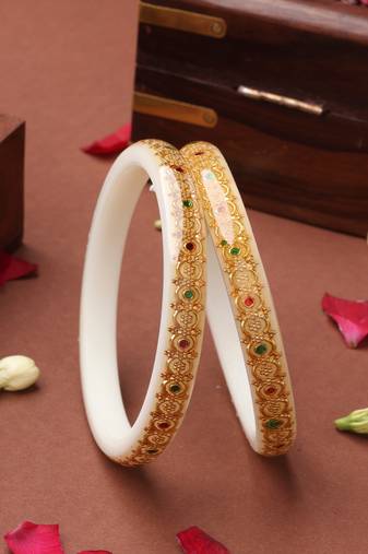White bangles with gold embellishments and floral designs