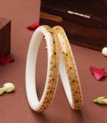 White bangles with gold embellishments and floral designs