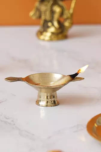 One golden decorative brass diya with stand and holder