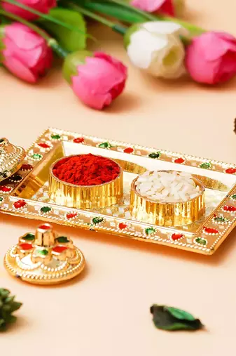 One golden decorative roli chawal holder, akshata haldi kumkum holder
