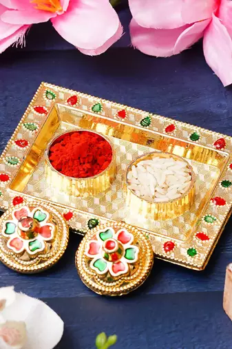 One golden decorative roli chawal holder, akshata haldi kumkum holder