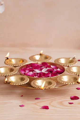 One golden handcrafted designer urli with 8 diyas
