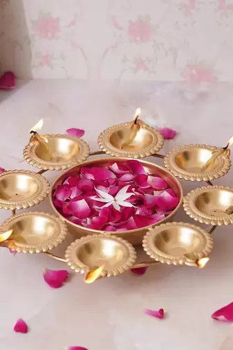 One golden handcrafted designer urli with 8 diyas