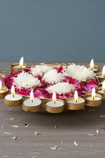One golden metal traditional peacock designer urli with 11 tea light holders