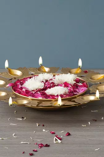 One golden metal handcrafted traditional designer urli with 9 lotus shape diyas
