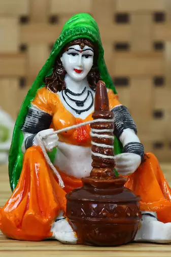 One rajasthani lady using makhan handi handcrafted decorative polyresin showpiece