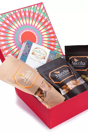 Red hamper box of assorted bites, crunchy coated cashews, crunchy coated peanuts, butter chakli sticks