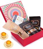 Red hamper box of assorted bites, crunchy coated cashews, crunchy coated peanuts, butter chakli sticks and t-lites