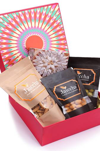 Red hamper box of kaju katlis, crunchy coated cashews, crunchy coated peanuts, butter chakli sticks