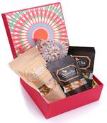 Red hamper box of kaju katlis, crunchy coated cashews, crunchy coated peanuts, butter chakli sticks