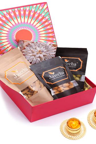 Red hamper box of kaju katlis, crunchy coated cashews, crunchy coated peanuts, butter chakli sticks and t-lites