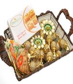 Diwali hampers-brown cane basket with besan barfi, almonds, toran  and 2 t-lites