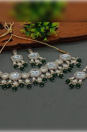 Elegant kundan-style green and white necklace, earrings, and tikka set