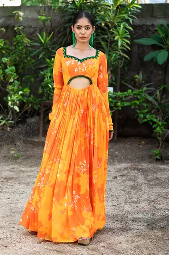 Yellow orange embroidered anarkali with green work and cut-out on the waist in the front and embroidered net dupatta.