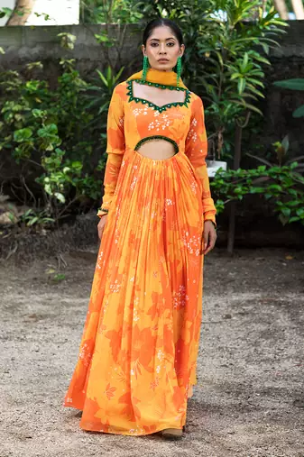 Yellow orange embroidered anarkali with green work and cut-out on the waist in the front and embroidered net dupatta.