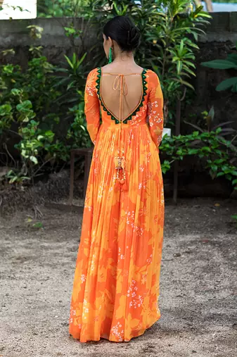 Yellow orange embroidered anarkali with green work and cut-out on the waist in the front and embroidered net dupatta.