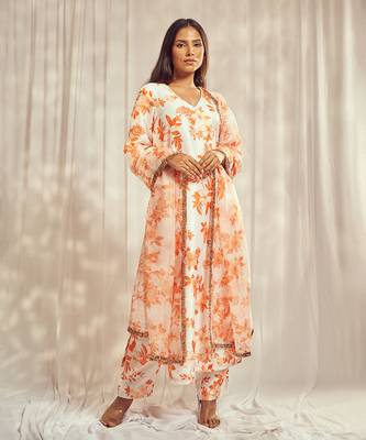 Burnt orange print kurti set paired with matching bottom and star organdie dupatta with gold trimming lace detailing. 1